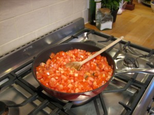 Fresh tomatoes added to onions and garlic