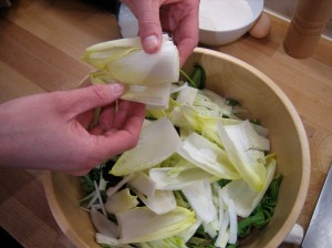 Separating chicory leaves and adding them to the bowl